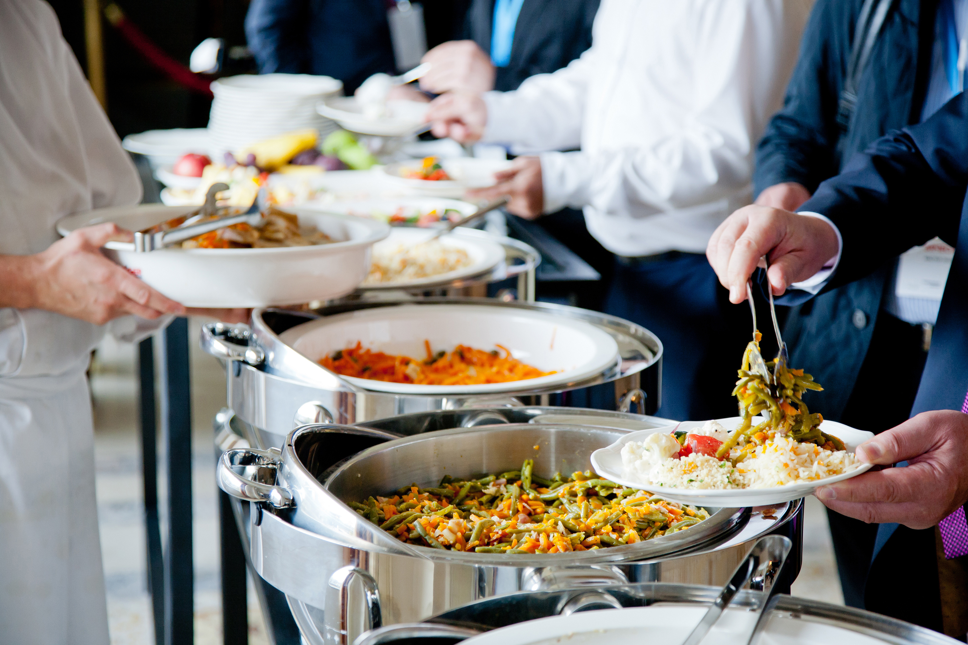 men in blue suits choosing food at a banquet